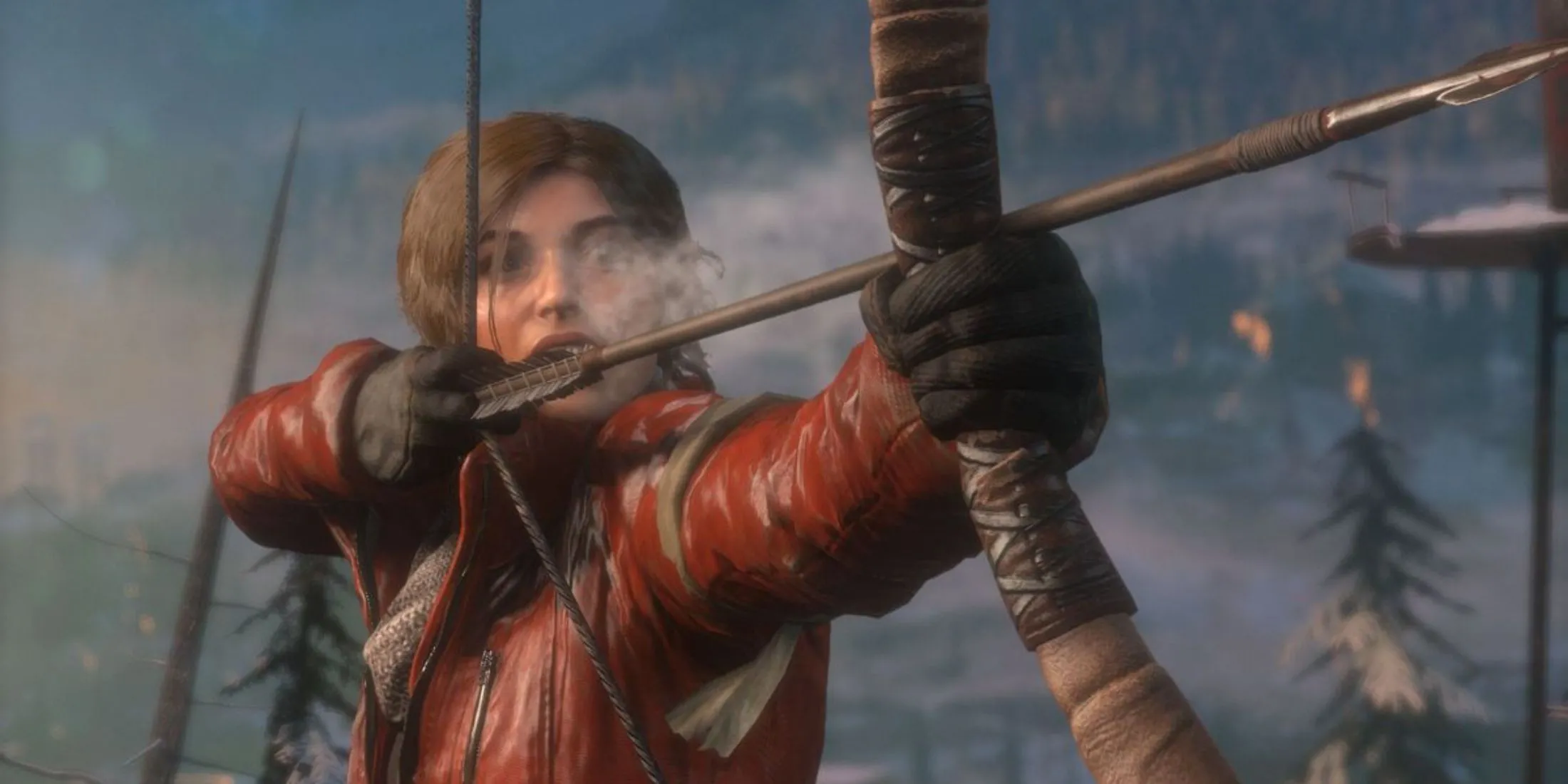 Lara Croft đang giương cung tên giữa khu rừng phủ đầy tuyết trong Rise Of The Tomb Raider